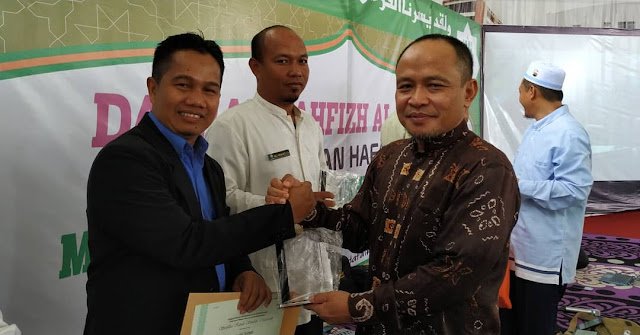 H. Haryanto menyerahkan sertifikat plakat dan kalender kepada kepala SMPIT Ukhuwah Syaiful Mukmin
